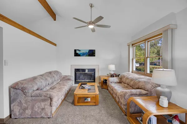 a living room with furniture a fireplace and a large window