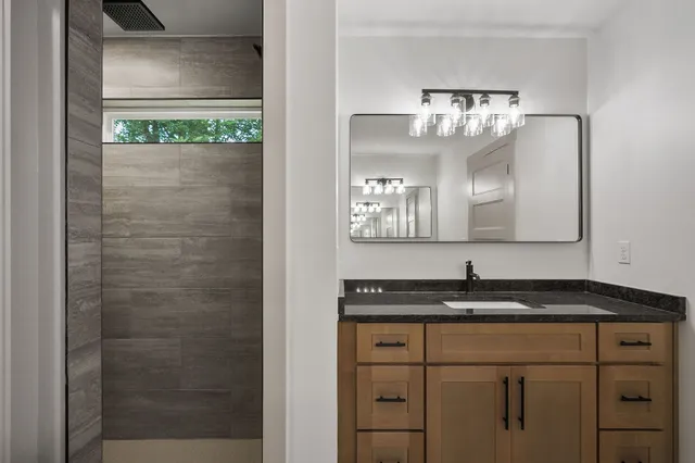 a bathroom with a granite countertop sink a mirror and a