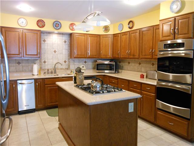 489 Pond Apple Road Clarksville, TN 37043 - Photo 4 of 17 The custom cabinets feature various pull-out baskets, trash can, lazy susan, under cabinet lighting, and quartz countertops. Beautiful porcelain tile backsplash and floor.
