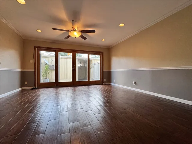 a view of an empty room with window and wooden floor