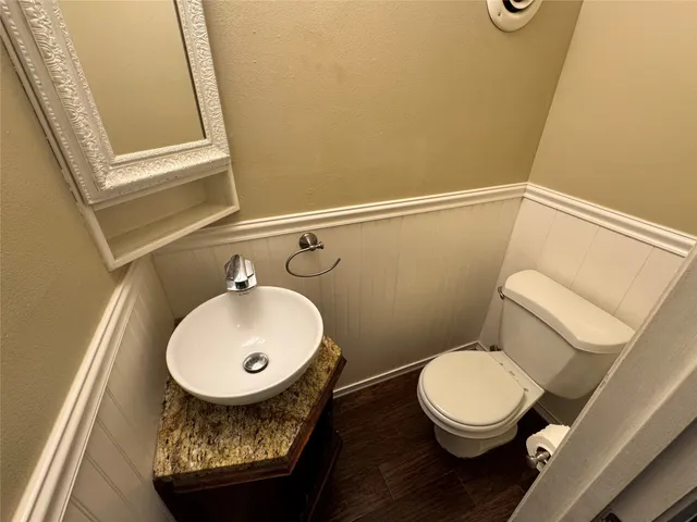 a bathroom with a toilet a sink and a mirror