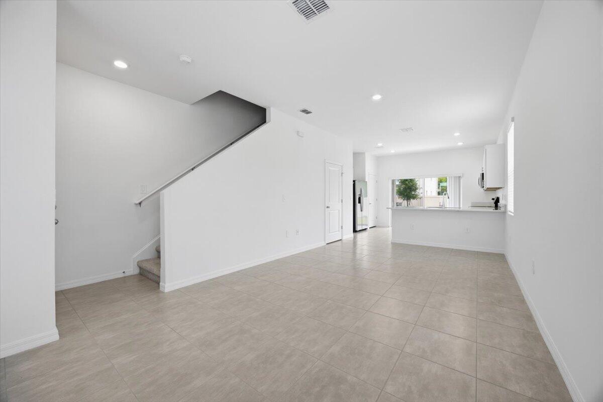 2907 Skyline Loop Kissimmee, FL 34758 - Photo 2 of 12 a view of an empty room with white walls and stairs