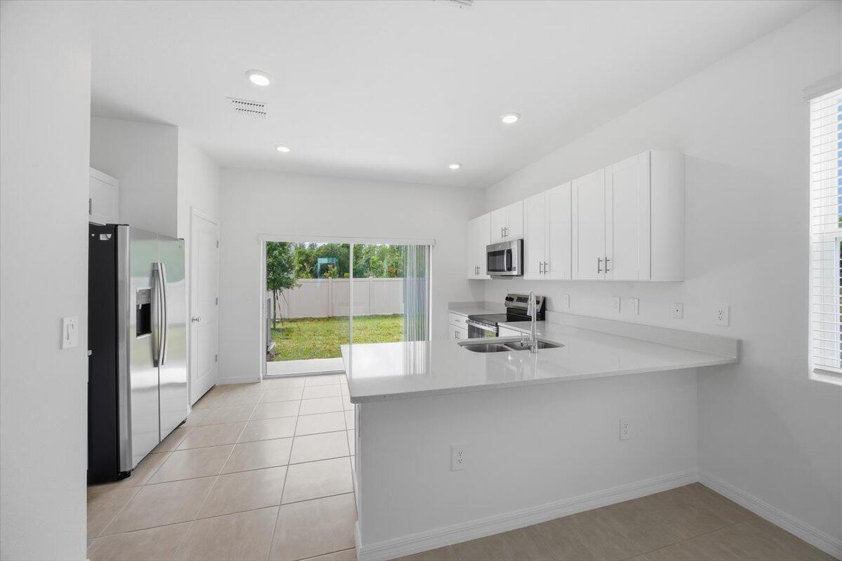 2907 Skyline Loop Kissimmee, FL 34758 - Photo 5 of 12 a large kitchen with kitchen island a large window in it and a sink