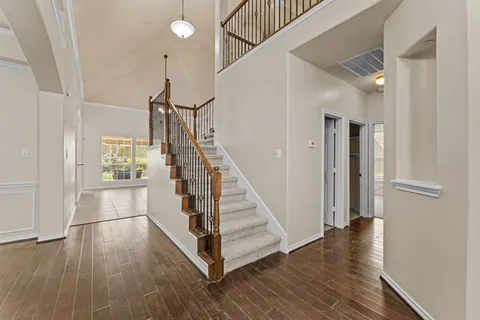 a view of a hallway with wooden floor and staircase