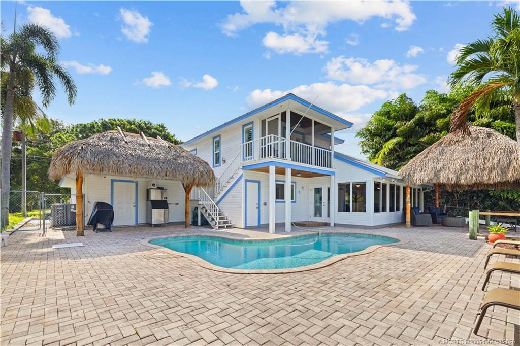 1359 Southwest Dyer Point Road Palm City, FL 34990 - Photo 36 of 55 a front view of a house with a yard and potted plants