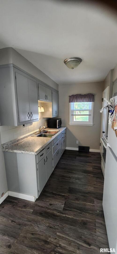 96 Highway 67 Alexis, IL 61412 - Photo 20 of 24 a kitchen with wooden floors and white appliances