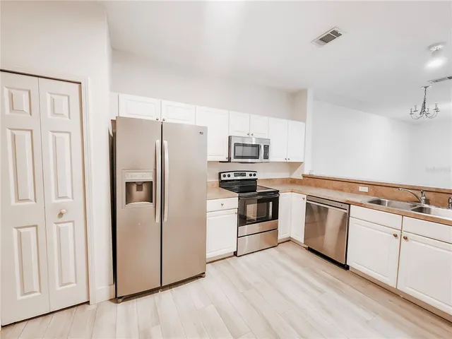 a kitchen with white cabinets and white appliances