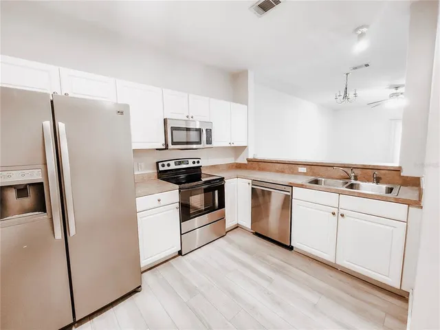 a kitchen with white cabinets and stainless steel appliances