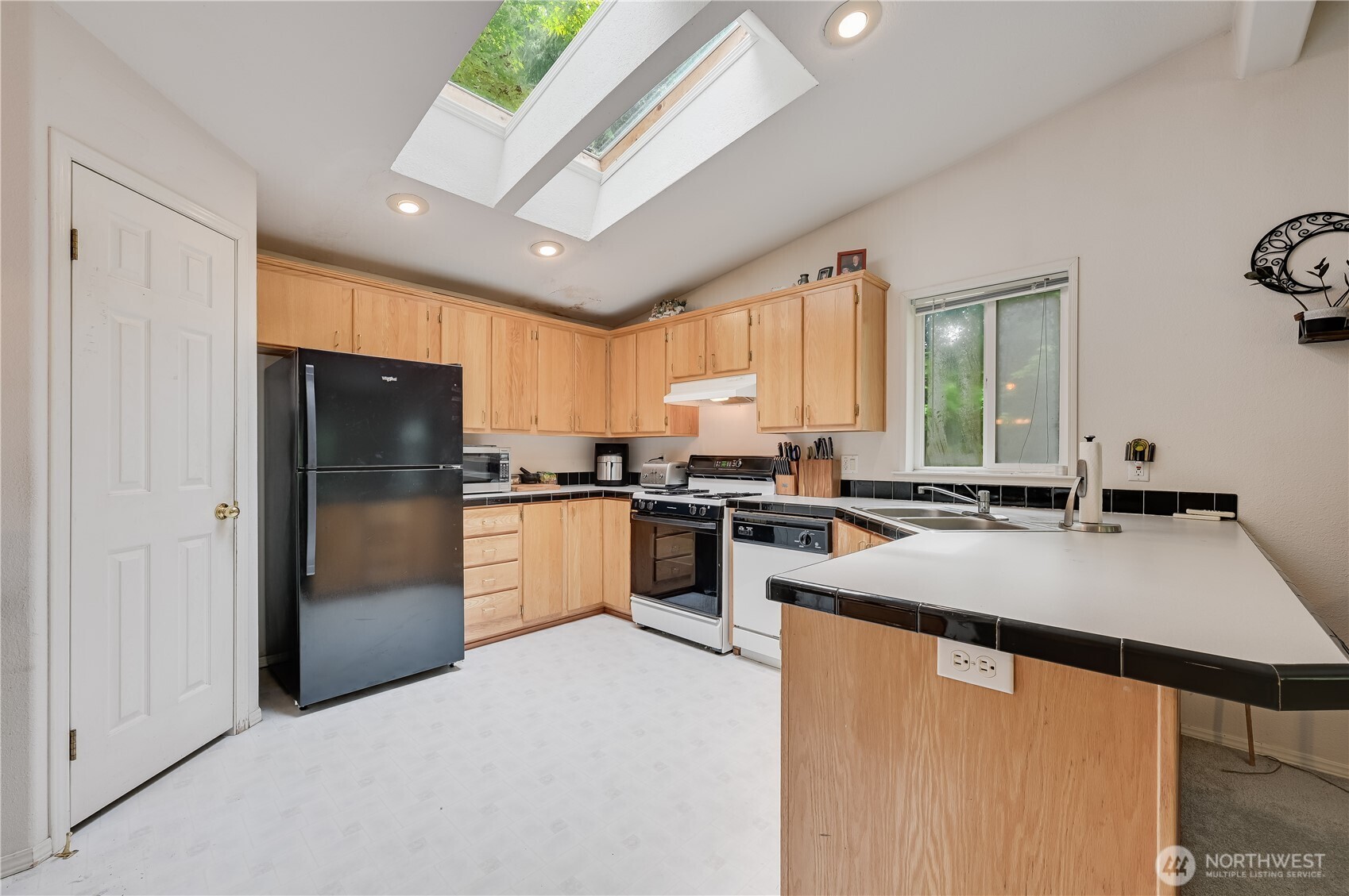 28818 Northeast Tolt Hill Road Carnation, WA 98014 - Photo 6 of 12 a kitchen with stainless steel appliances granite countertop a refrigerator a sink dishwasher a stove with white cabinets and wooden floor