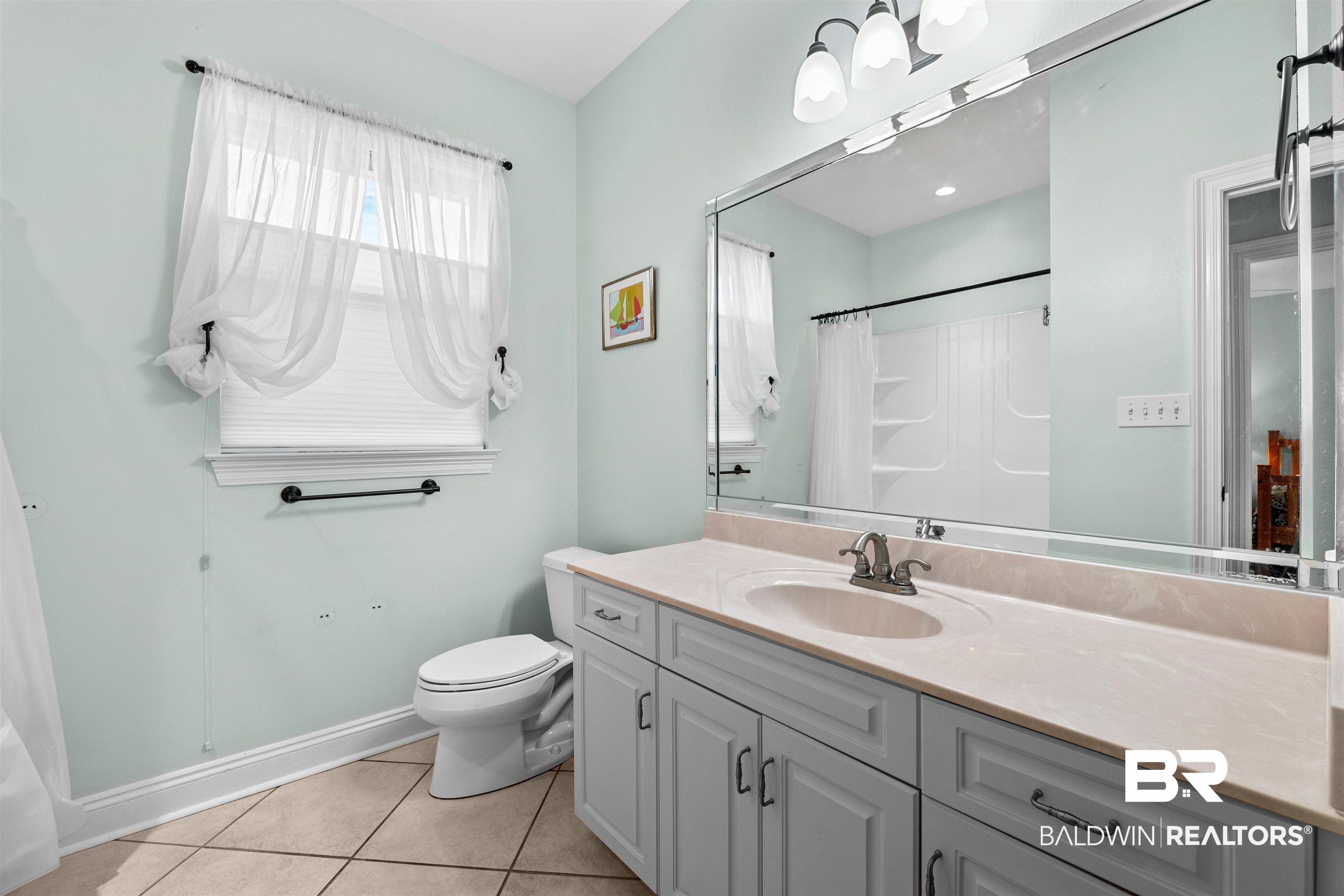 237 Hemingway Loop Foley, AL 36535 - Photo 19 of 49 Bathroom with vanity, a shower with shower curtain, baseboards, tile patterned floors, and toilet