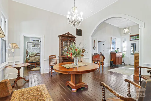 a living room with furniture a chandelier and a dining table