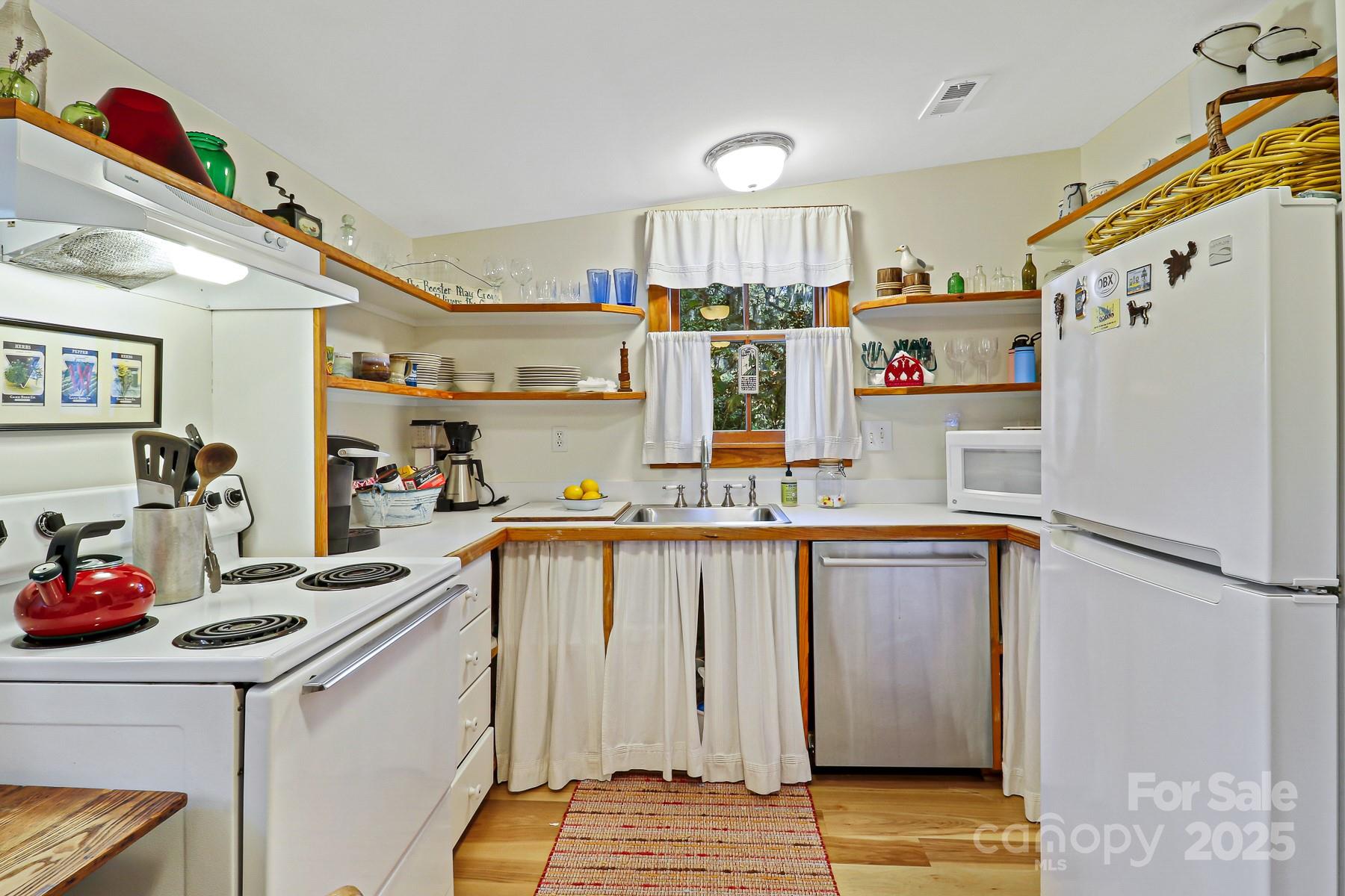 131 Pritchard Street Bluffton, SC 29910 - Photo 39 of 47 a kitchen with granite countertop a refrigerator a sink and wooden floor
