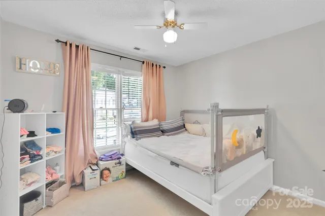 a bedroom with a bed flat screen tv and a window