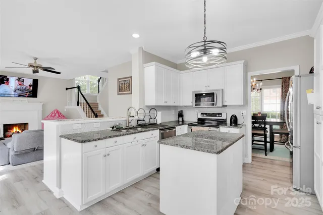 a kitchen with granite countertop stainless steel appliances a sink stove and refrigerator