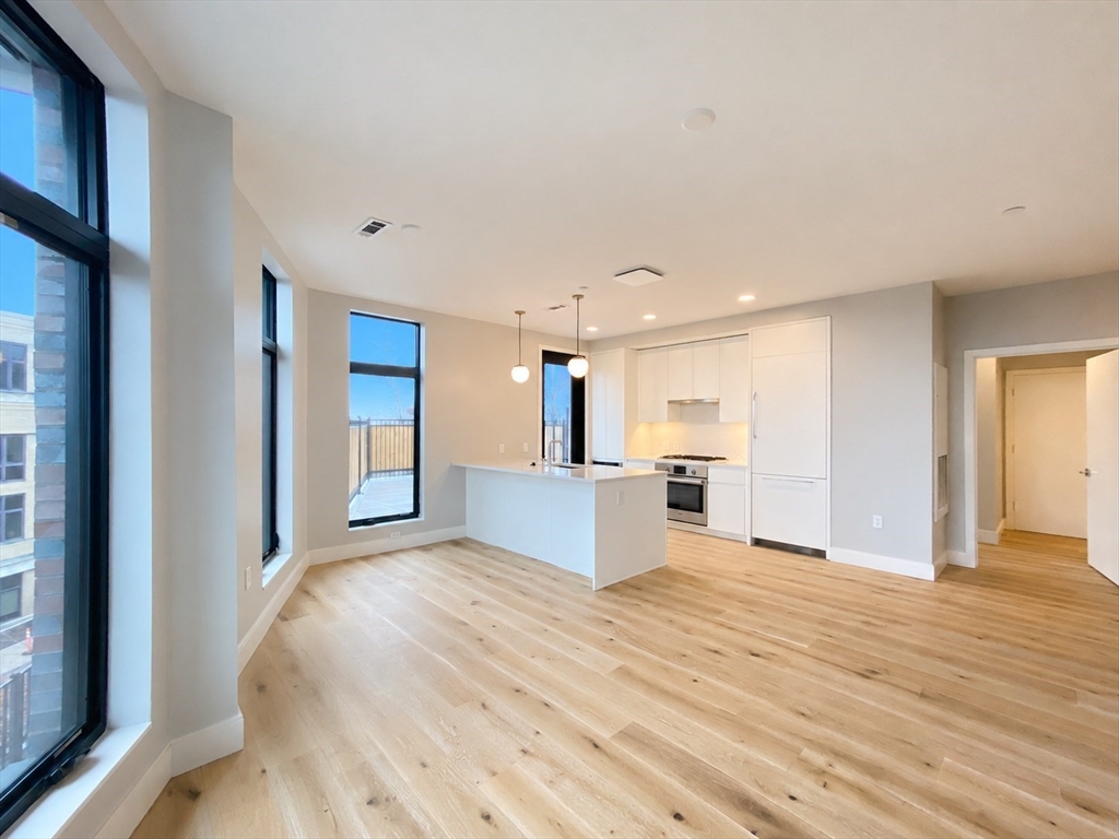 191 Washington Street, Unit 301 Boston, MA 02135 - Photo 7 of 40 a view of kitchen with kitchen island sink and refrigerator