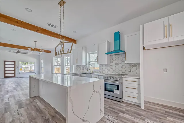 a kitchen with kitchen island granite countertop a stove and a sink