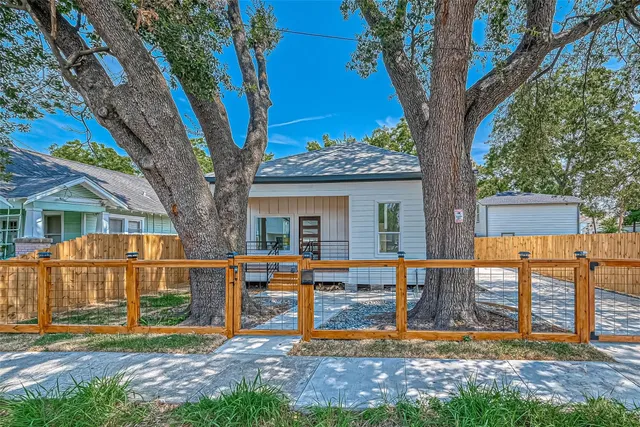 a view of a house with backyard and a tree