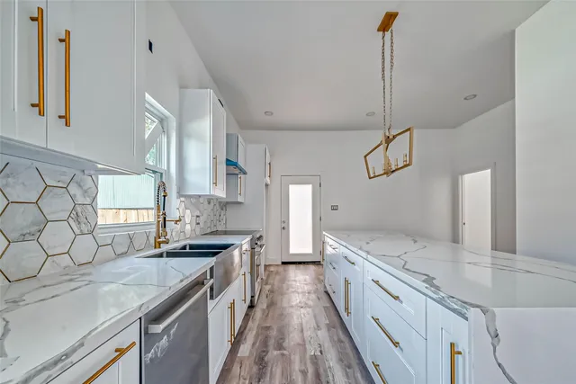 a kitchen with stainless steel appliances granite countertop a sink stove and refrigerator