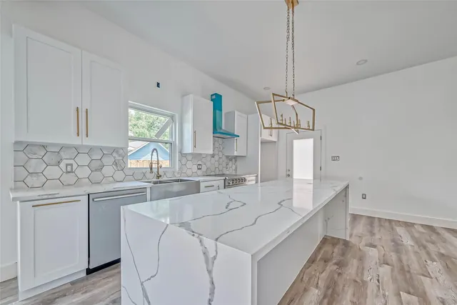 a kitchen with stainless steel appliances a sink stove and cabinets