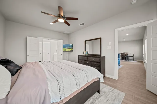 a spacious bedroom with a bed and a chandelier