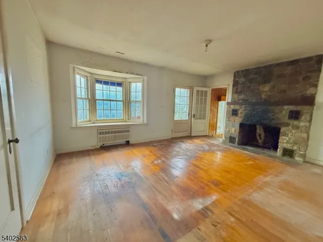an empty room with windows and fireplace