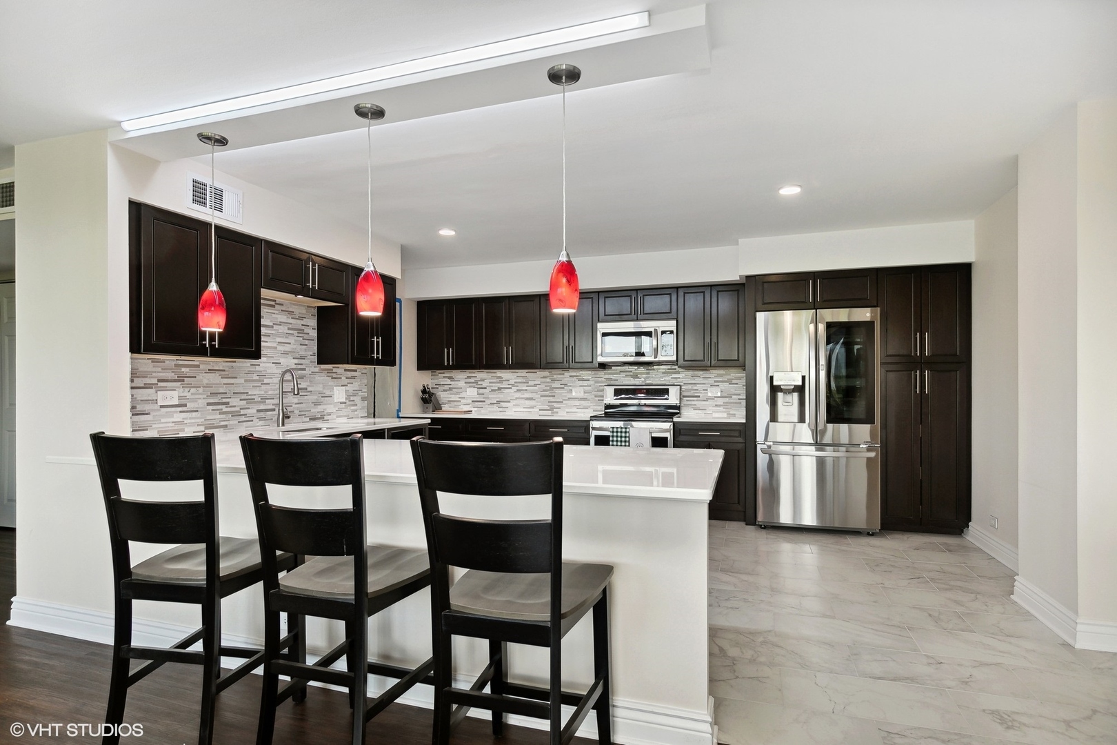 101 Bar Harbour Road, Unit 6E Schaumburg, IL 60193 - Photo 3 of 23 a kitchen with stainless steel appliances kitchen island granite countertop a table chairs sink and cabinets