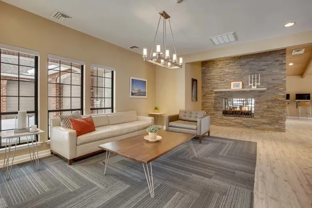 a living room with furniture a fireplace and a chandelier