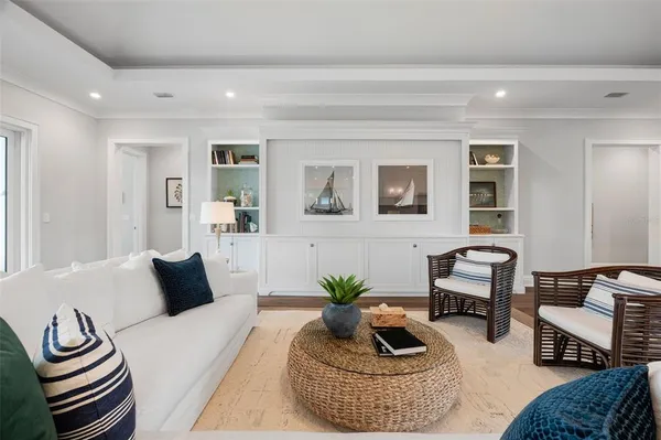 a room with kitchen island a large window cabinets a sink and stainless steel appliances