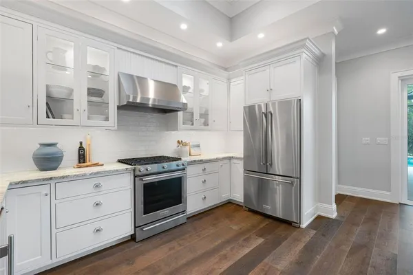 a view of a hallway with wooden floor windows and a chandelier