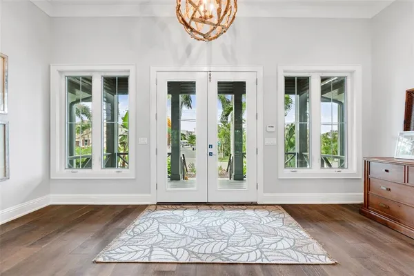 a living room with furniture a large window and a chandelier