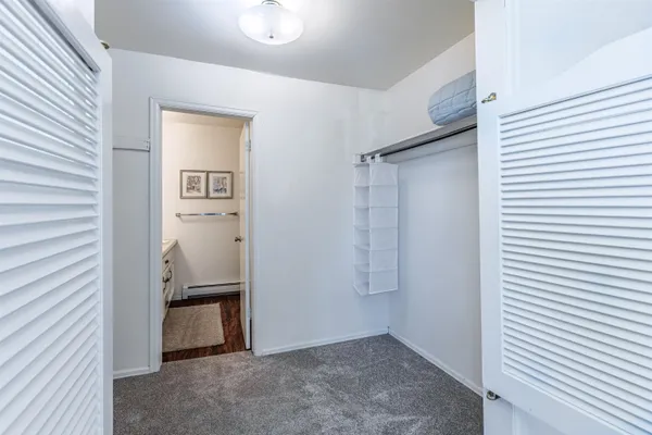 a view of a hallway with closet and bathroom