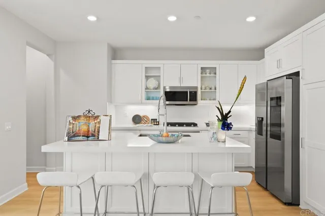 a kitchen with stainless steel appliances granite countertop a refrigerator and a stove top oven