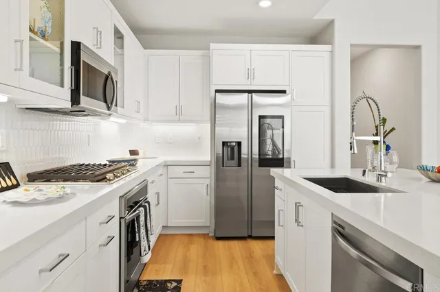 a kitchen that has a sink and a stove top oven