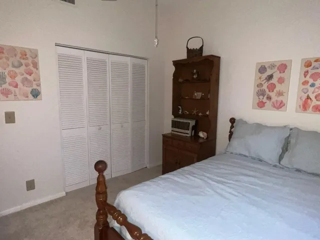 a bedroom with a bed and a painting on the wall