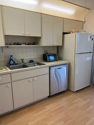 a kitchen with a sink a refrigerator and cabinets