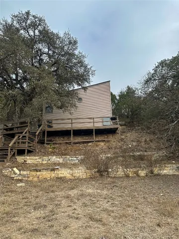 a view of a backyard with chairs and a large tree
