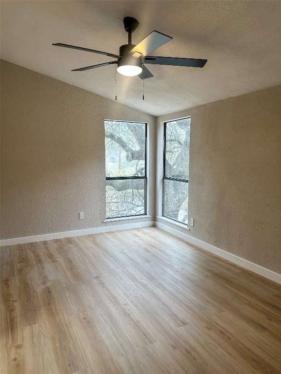 2709 Long Bow Trail Austin, TX 78734 - Photo 9 of 15 an empty room with wooden floor chandelier fan and windows