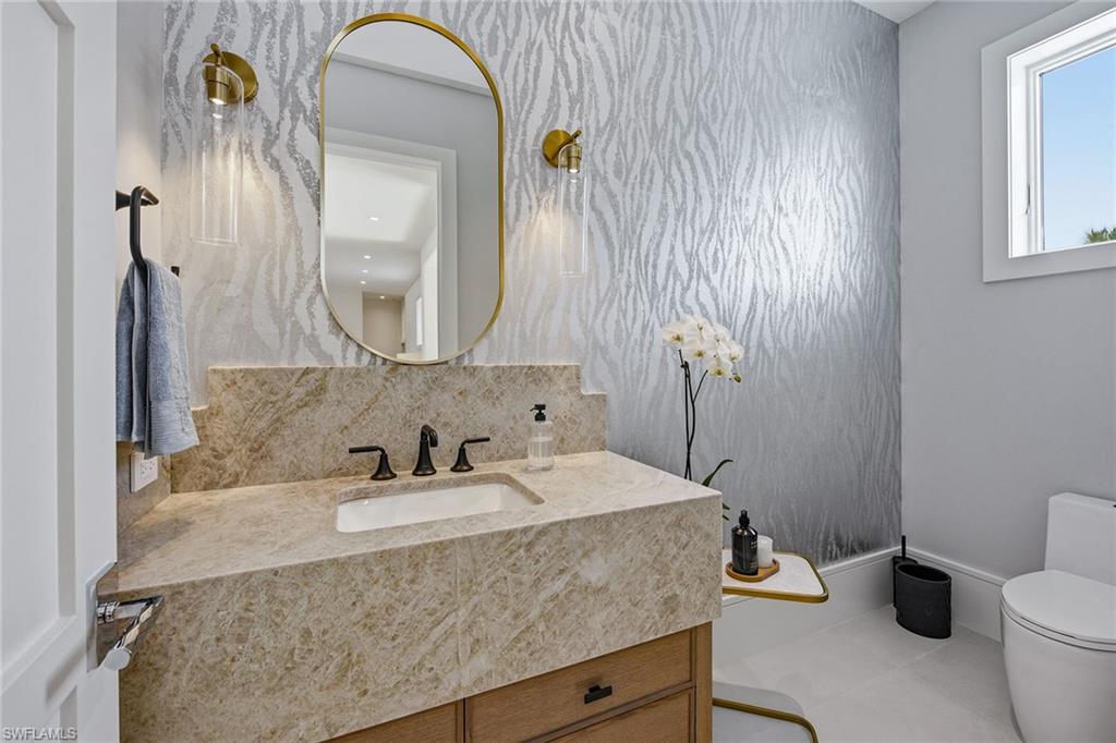 529 Neapolitan Way Naples, FL 34103 - Photo 22 of 26 a bathroom with a granite countertop sink and a mirror