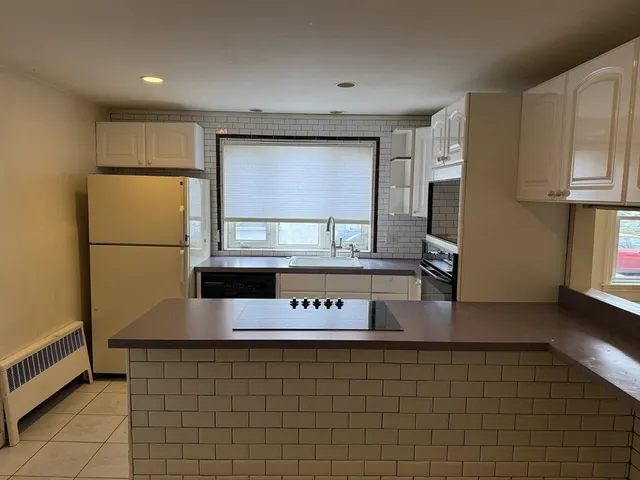 a kitchen with stainless steel appliances granite countertop a sink and a refrigerator