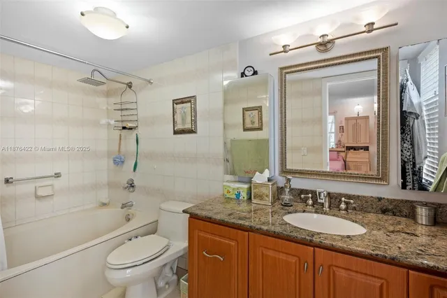 a bathroom with a granite countertop sink toilet mirror and shower