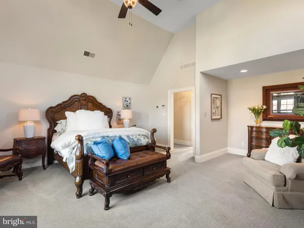 a bedroom with a large bed and a flat tv screen on dresser