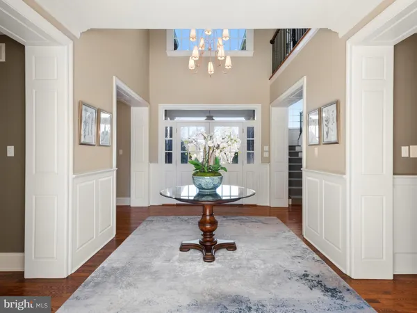 a kitchen with kitchen island granite countertop wooden floors and a view of living room