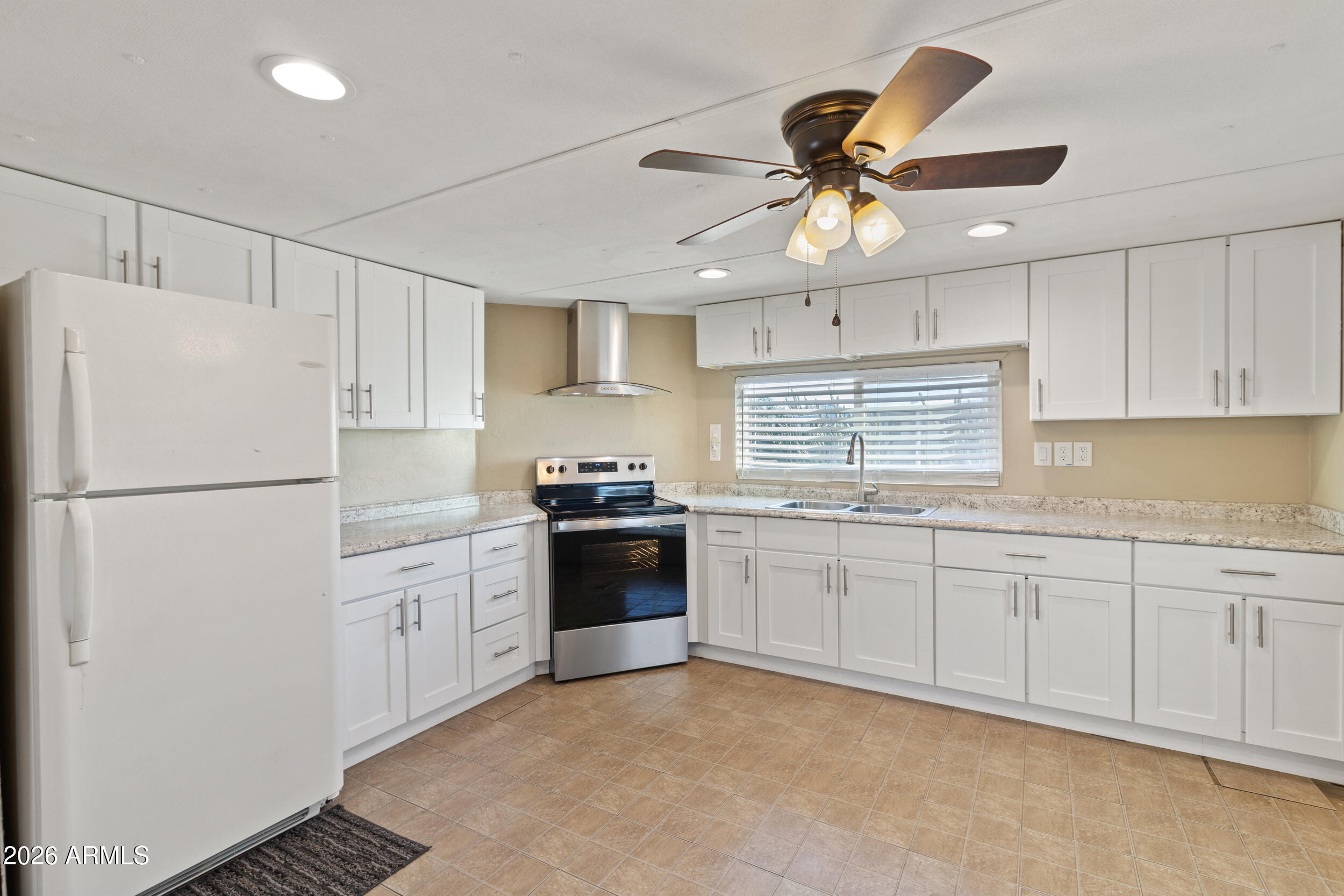 a kitchen with granite countertop a refrigerator a sink a stove a microwave and island