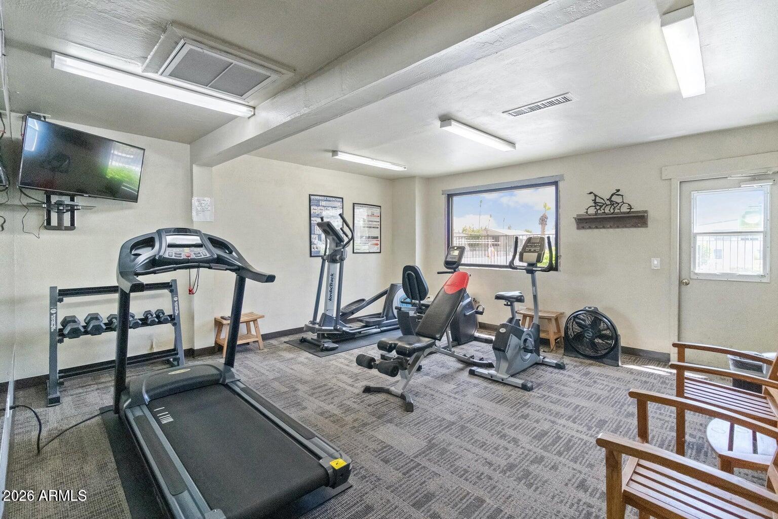 535 South Alma School Road, Unit 69 Mesa, AZ 85210 - Photo 37 of 59 a room with gym equipment and a flat screen tv