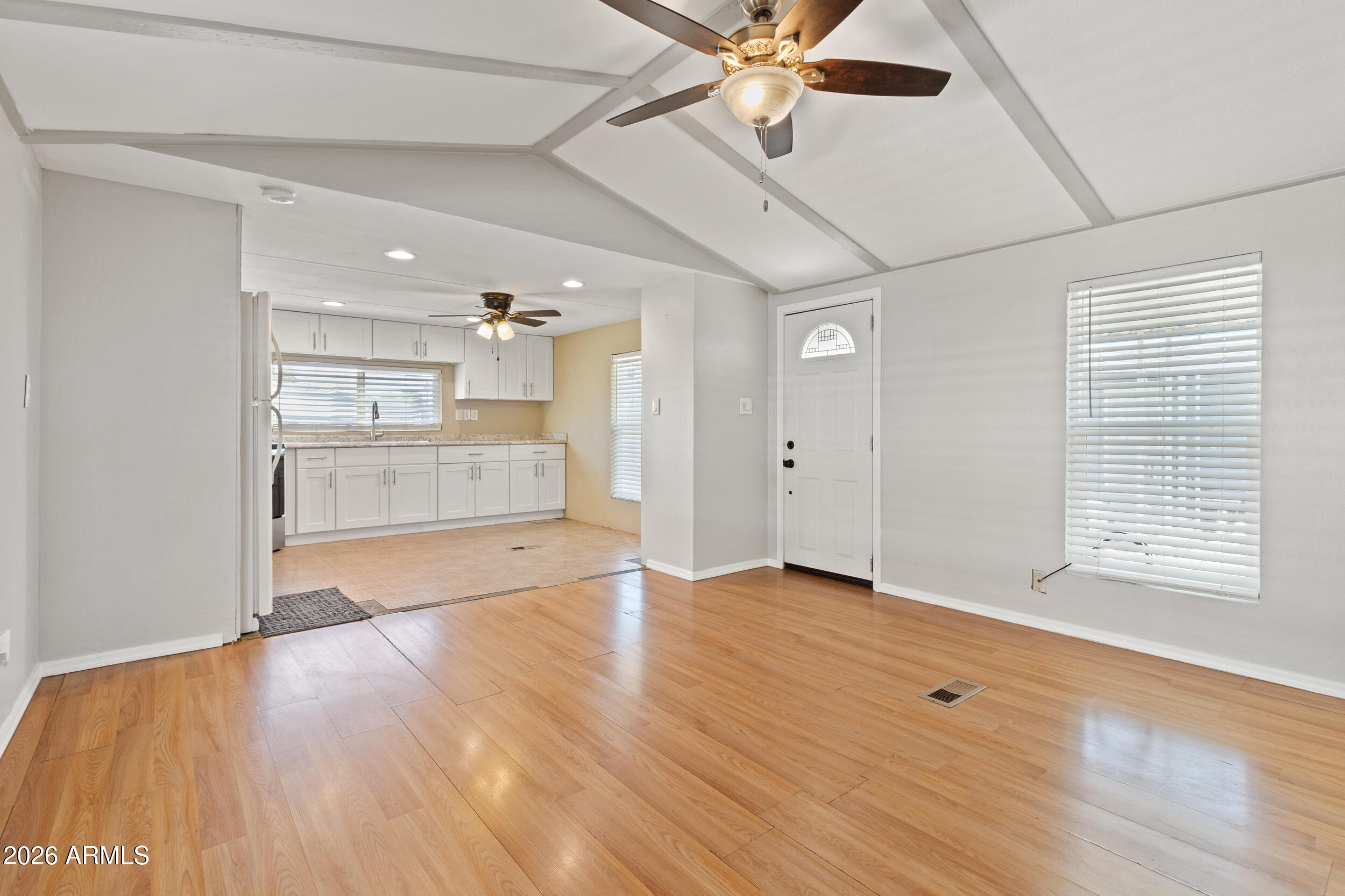 535 South Alma School Road, Unit 69 Mesa, AZ 85210 - Photo 6 of 59 an empty room with wooden floor a ceiling fan and windows