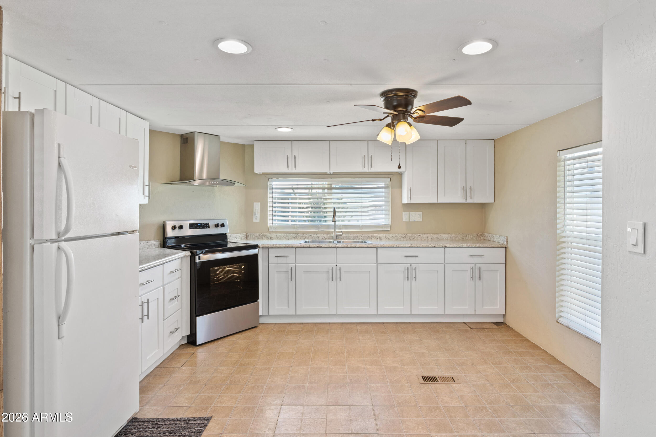 535 South Alma School Road, Unit 69 Mesa, AZ 85210 - Photo 9 of 59 a kitchen with granite countertop a refrigerator stove top oven and sink