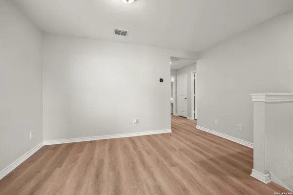 a view of an empty room with wooden floor