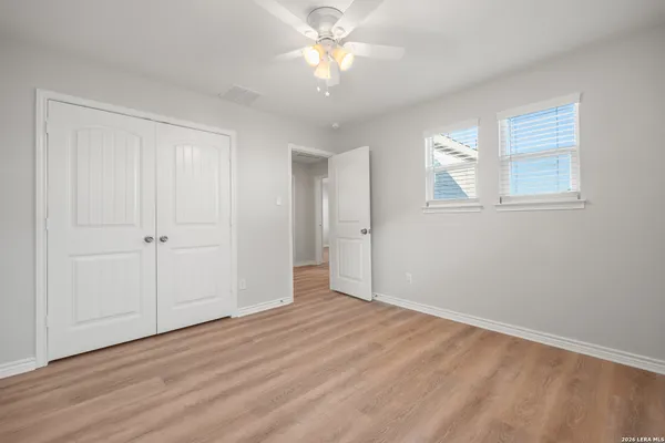 a view of an empty room with window and wooden floor