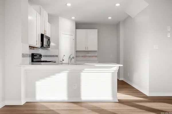 a kitchen with stainless steel appliances granite countertop a stove a sink and a microwave