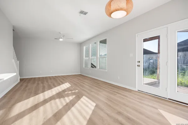 an empty room with wooden floor and windows